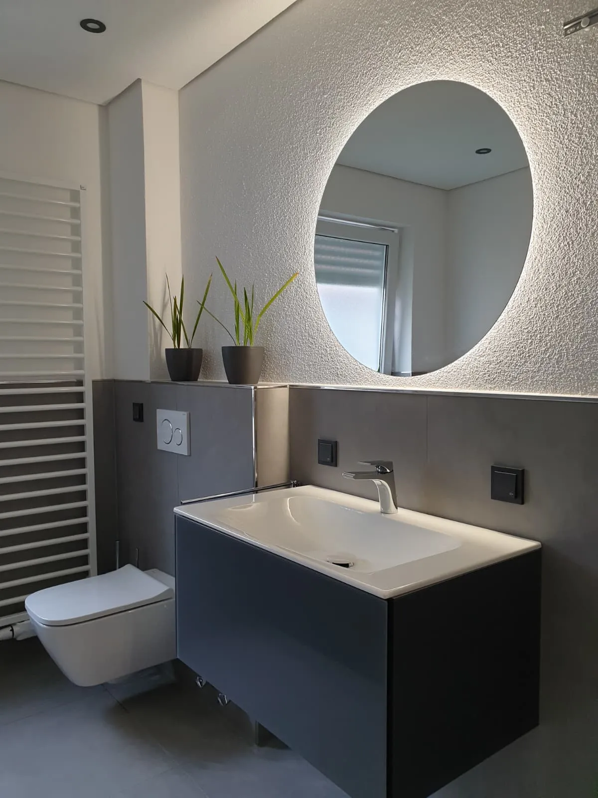 Badsanierung in Heilbronn — modernes Badezimmer mit freistehendem Waschtisch und beleuchtetem Spiegel